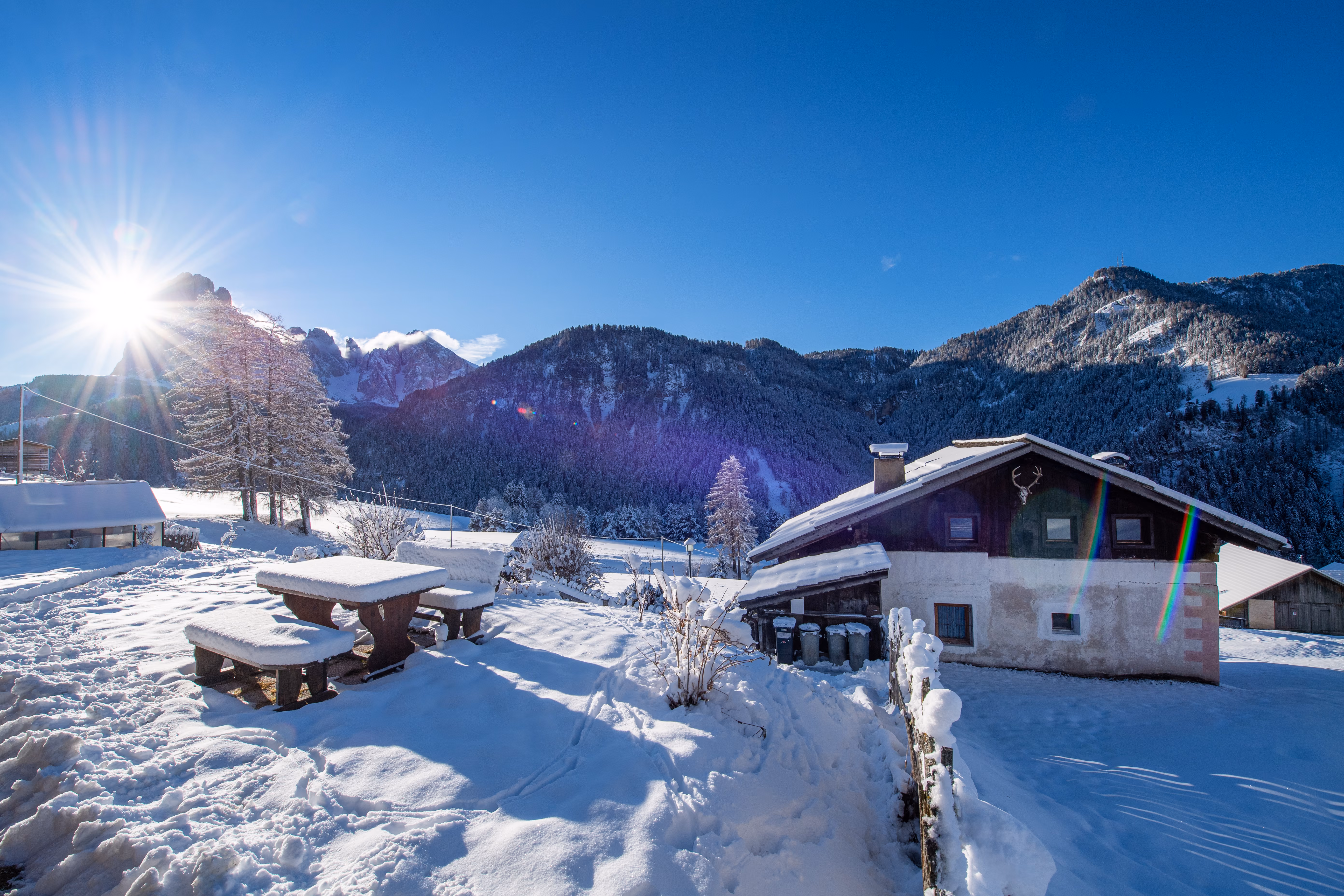The garden table under snow, sun over the peaks