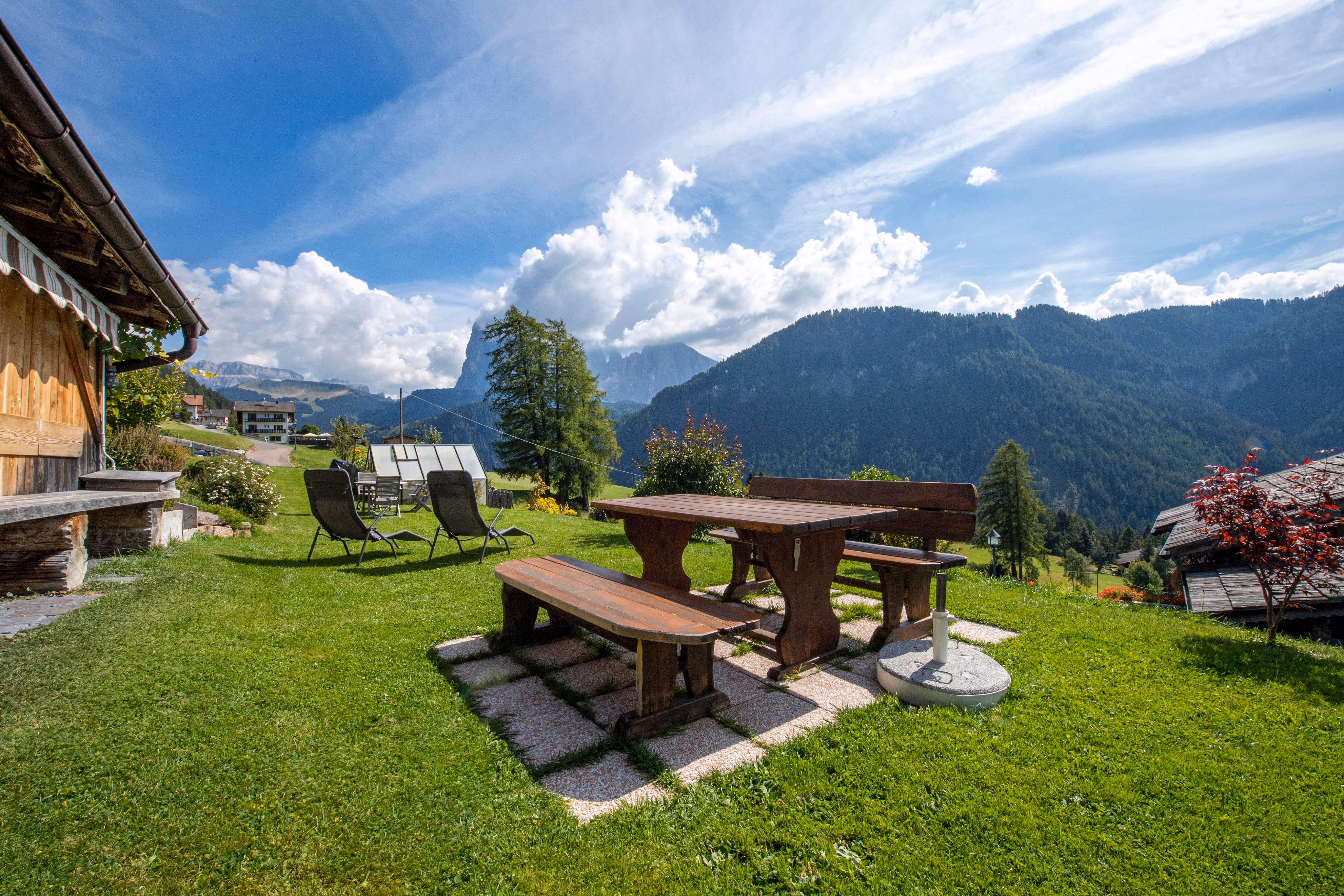 Loungers on the lawn, the valley falling away below the house